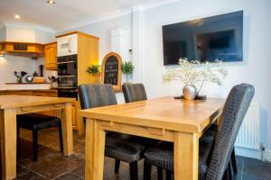 uma cozinha e sala de jantar com mesas e cadeiras de madeira em CROYDE BEACH HAVEN 5 Bedrooms em Croyde