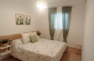 a bedroom with a bed and two windows at Dunas de Águilas in Águilas