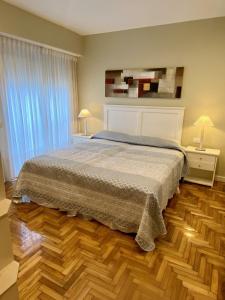 1 dormitorio con 1 cama y suelo de madera en Depto 3 Ambientes Zona Playa Grande Frente al Mar en Mar del Plata