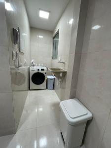 Baño blanco con aseo y lavamanos en Seu lar no melhor de Recife - Boa Viagem., en Recife