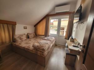 a small bedroom with a bed and a window at Guest Rooms Kostovi in Nesebar