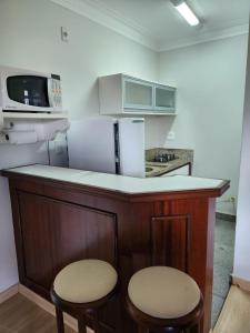 a kitchen with a counter with two stools at AGUAS DE SÃO PEDRO VIP in Águas de São Pedro