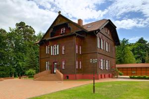 a large wooden building with a gambrel roof at Jagdschloss Waldsee in Waldsee