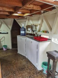 a kitchen with white cabinets and a sink in a room at Alquimia del Hualle in Melipeuco