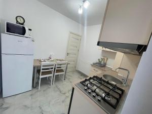 a small kitchen with a stove and a table at Pensiunea Giulia in Afumaţi