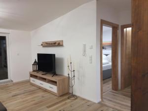 a living room with a television and a bed at Appartement Seeleben in Bodensdorf