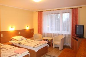 a hotel room with two beds and a television at Zajazd Jagnar in Trzcianka