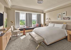 a bedroom with a large bed and a living room at The Newbury Boston in Boston