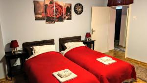 2 camas en una habitación con sábanas rojas en Peti, en Belgrado