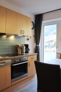 a kitchen with a stove top oven next to a window at Chasa Patria in Ischgl