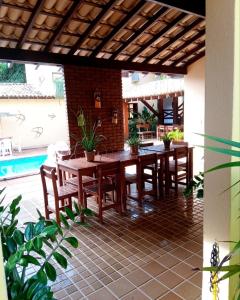 a patio with a table and chairs and a pool at Pousada Clara in Cumuruxatiba