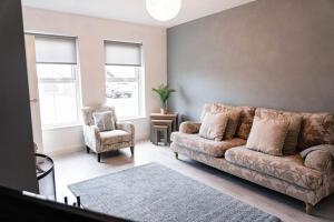 a living room with a couch and a chair at Glen Burren House in Newcastle