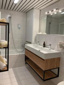 ein Badezimmer mit einem Waschbecken, einem Spiegel und einer Badewanne in der Unterkunft Appartement Posthäusl in Sölden