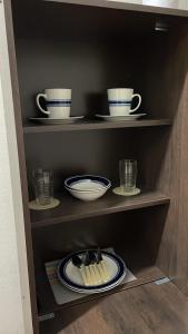a shelf with dishes and cups and plates on it at Pequeño departamento in Asuncion