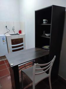 a dining table and a chair in a kitchen at Pequeño departamento in Asunción