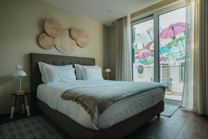 a bedroom with a bed and a window with umbrellas at XPT Águeda - Boutique Apartments in Águeda