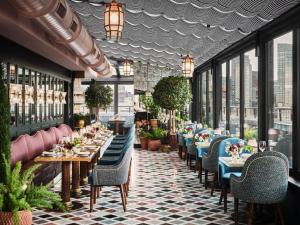 a restaurant with tables and chairs and windows at The Newbury Boston in Boston