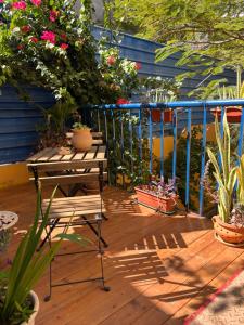 une terrasse en bois avec une table et des plantes en pot dans l'établissement Charming 2BR Guest Suite with Ocean View, à Praia