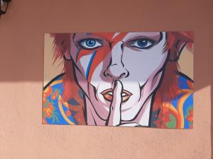 een schilderij van een vrouw met haar vinger in haar mond bij THE HOME OF MUSIC STARS in Catania