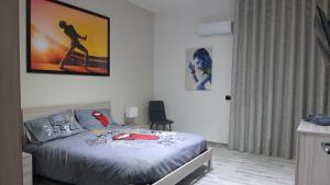 een slaapkamer met een bed en een foto aan de muur bij THE HOME OF MUSIC STARS in Catania