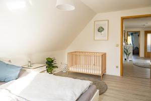 a bedroom with a crib and a room with a crib at Ferienhaus Tidenkieker in Nordstrand