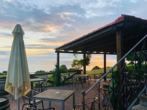 an outdoor patio with tables and a umbrella at Pikua Landetxea in Mutriku