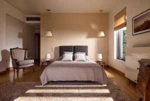 a bedroom with a large bed and a chair at La Residenza in Katsíngrion