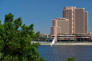 a white bird flying over a body of water with buildings at InterContinental Cairo Semiramis by IHG in Cairo