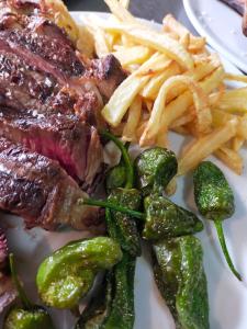 a plate with steak and french fries and pickles at Pikua Landetxea in Mutriku