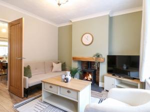 a living room with a couch and a fireplace at The Crooked Cottage in Ashbourne
