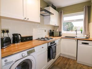 a kitchen with a washing machine and a washer at The Crooked Cottage in Ashbourne
