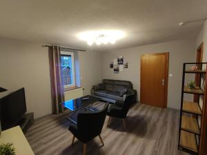a living room with a couch and a table at Appartement 5 personnes à deux kilomètres des pistes in La Bresse