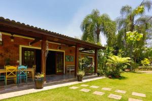 a house with a patio and a table in a yard at LINDA CHACARA EM CONDO A 40 MIN DE SP com piscina climatizada, churrasqueira, wifi, 5 quartos e muita natureza in Cajamar