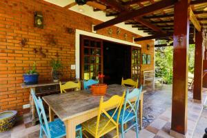 a patio with a wooden table and chairs at LINDA CHACARA EM CONDOM 30 MIN DE SP piscina climatizada, churrasqueira, wifi, 5 quartos, amplo jardim in Cajamar