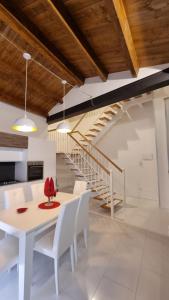 a dining room with a white table and white chairs at B&B Palazzo del Contestabile in Troia