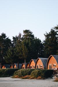 a row of houses with trees in the background at Ocean Village Resort in Tofino