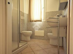 a bathroom with a toilet and a sink and a shower at Casa Arborea in Castelsardo