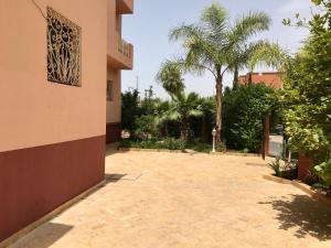 een binnenplaats van een huis met palmbomen bij Appartement les résidences du rêve in Marrakesh