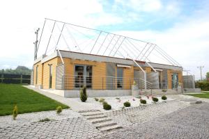 a small yellow building with a large roof at Apartamenty pod Wilczakiem in Złotoryja