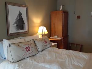 1 dormitorio con 1 cama con sábanas y almohadas blancas en Waybury Inn, en East Middlebury