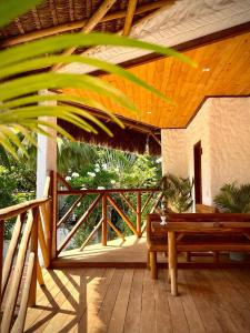 porche de madera con banco en la cubierta en Casa Palmeira en Pipa