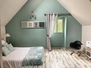 ein Schlafzimmer mit einer grünen Wand mit einem Bett und einem Stuhl in der Unterkunft les demeures de Kerbosser in Ploeren