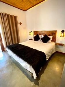 um quarto com uma cama grande e um cobertor preto em Casa Palmeira em Pipa