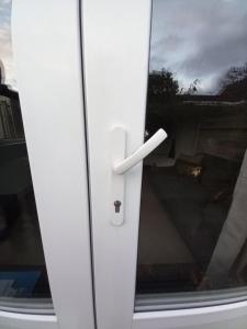 a white door with a handle on a window at Nieuw Holiday home Oostkapelle centrum in Oostkapelle