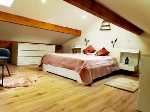 a bedroom with a large bed and wooden floors at Chaleureuse Maisonnette Lyon in Meyzieu