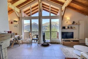 una sala de estar con una gran ventana con vistas a las montañas en Chalet La Plagne Montalbert 50m des pistes, en La Plagne Tarentaise