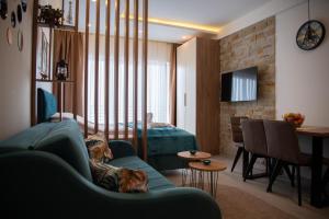 a living room with a blue couch and a bedroom at Apartman Larisa in Kopaonik