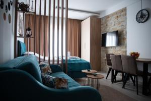 a living room with a blue couch and a dining room at Apartman Larisa in Kopaonik