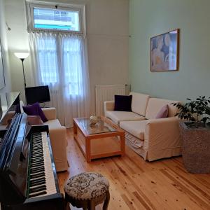 a living room with a couch and a piano at Maria's apartments in Thessaloniki