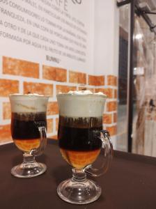 two glasses of beer sitting on top of a table at Eco Bunnu Inn in Cusco